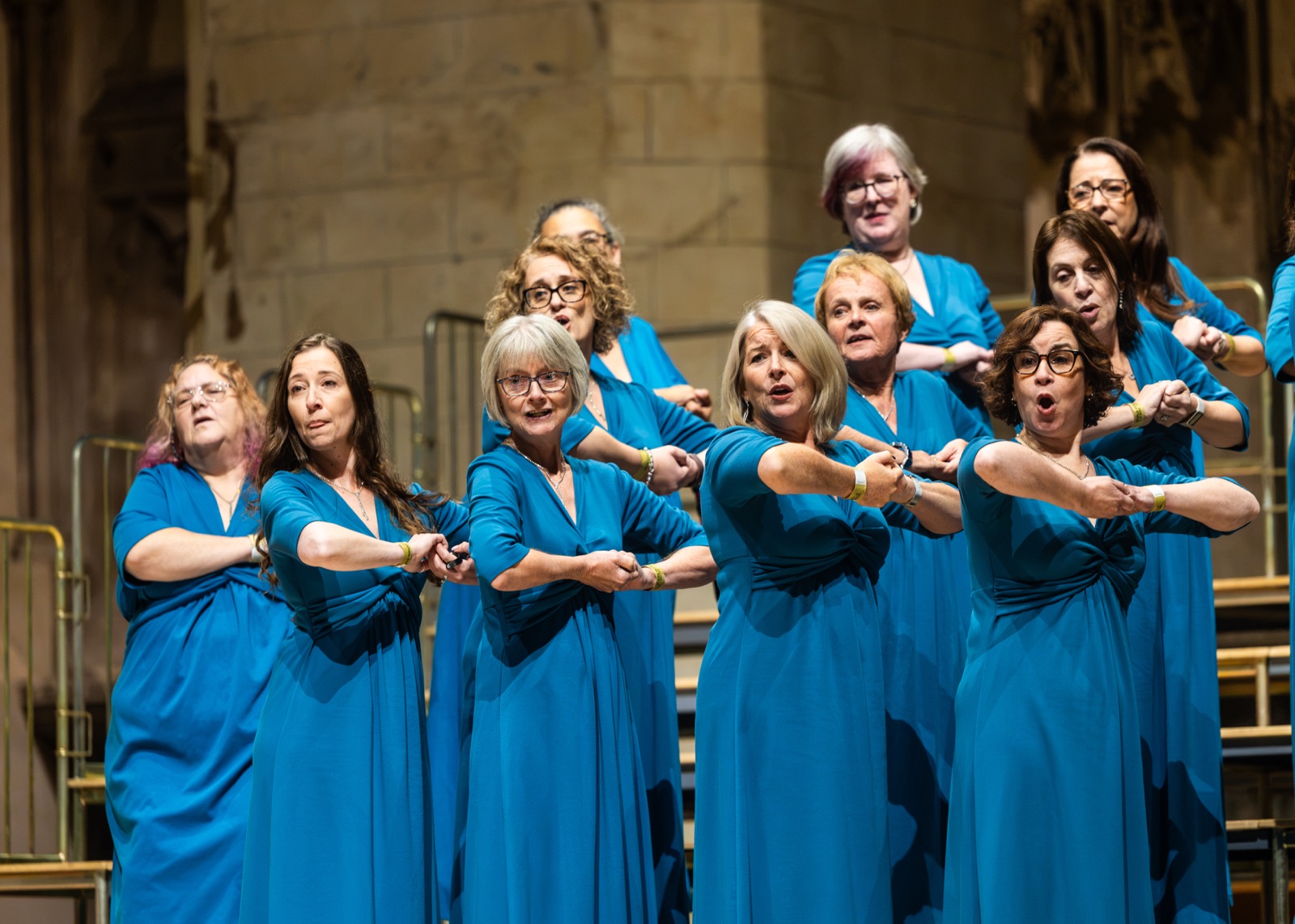 A choir in blue performing in St Albans Cathedral