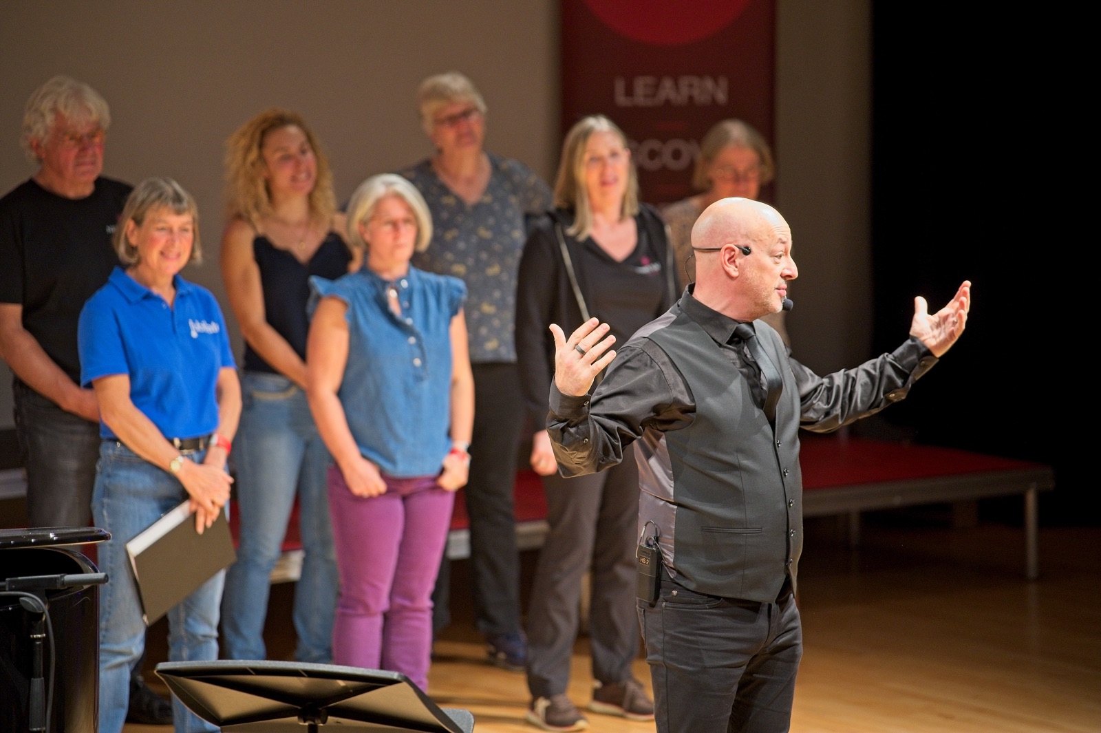 A workshop leader coaching a small group of singers