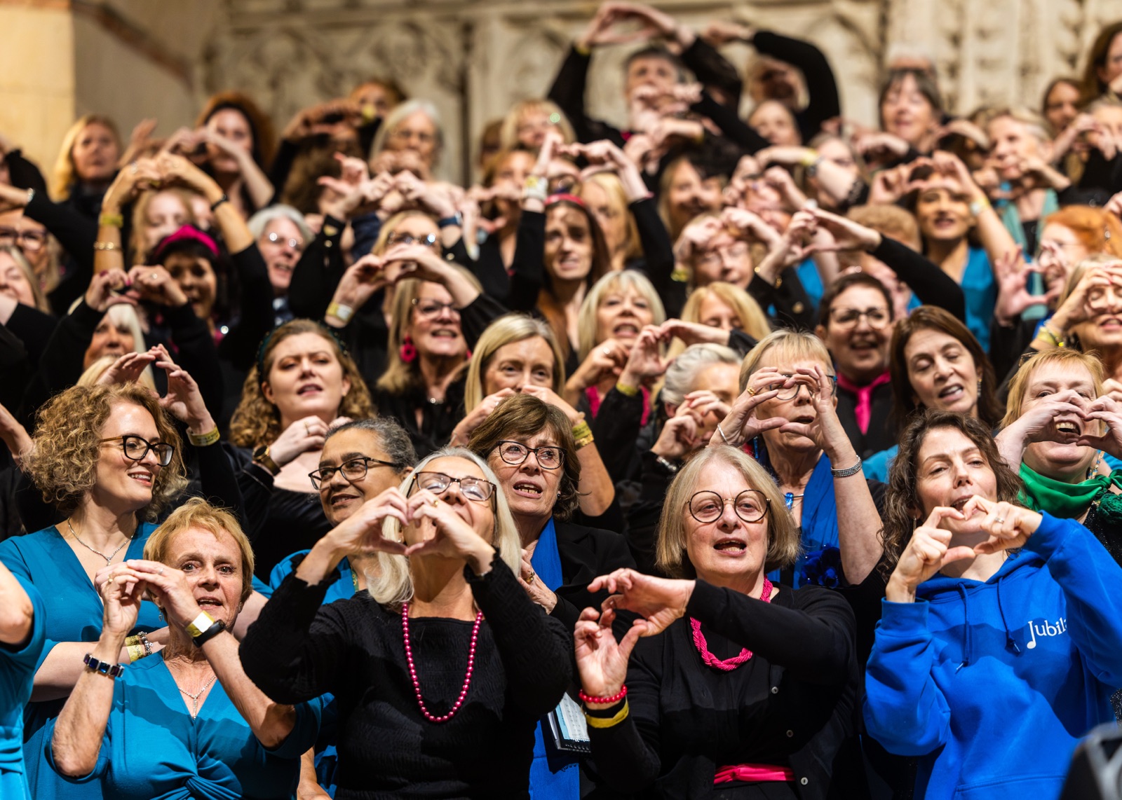Singers making heart shapes with their hands at World Voices Festival