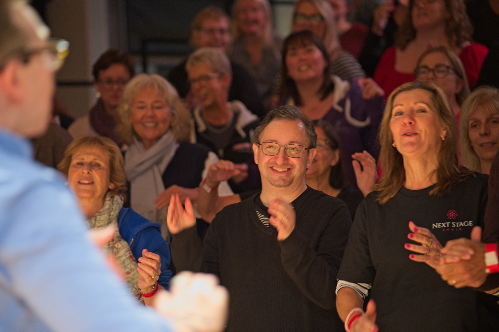 Singers smiling and clapping during a World Voices Festival workshop